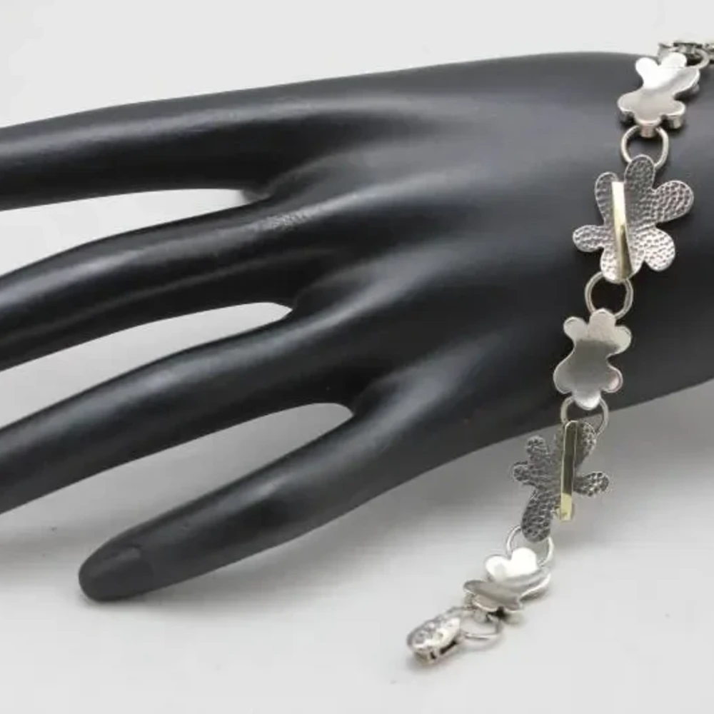 Браслет из серебра 925 пробы с цветочным узором и золотой отделкой.